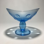 Delicado centro de mesa em vidro moldado na co azul, decorado com detalhes circulares em alto relevo. Dimensões: 12 cm x 13,5 cm x 15 cm.