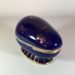 Antigo e delicado pote oval em porcelana esmaltada na cor azul cobalto com detalhes gravados à Ouro. Pequenos sinais de desgaste. Dimensões: 8 cm x 7 cm x 11 cm.
