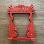 Belo arco oriental em madeira patinada de vermelho com figuras de dragões e detalhes vegetalistas talhados à mão. Dimensões: 60 cm x 48 cm.