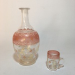 Delicada garrafa em vidro com detalhes e perolados pintados a mão , acompanha 1 copo. Não possui tampa. Dimensões: 17 cm x 8 cm. / copo 5 cm.