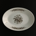 NADIR FIGUEIREDO - Antiga travessa em cerâmica esmaltada decorada com arranjos florais e estilizado na cor marrom. Pequenos sinais de desgastes.Dimensões: 20 cm x 28 cm.