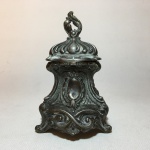 Antigo tinteiro de metal cinzelado com resquício de banho de prata decorado com folhagens e  volutas. Presença de sinais do tempo. Dimensões: 12,5 cm.