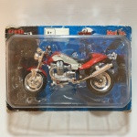 Moto de miniatura, modelo GUZZI V 10 CENTAURO, escala 1:18, construído em metal, plástico e rodas emborrachas. Embalagem lacrada. Coleção Maisto - 2 Wheelers - Fresh metal. Dimensões da embalagem: 6 cm x 12 cm x 17 cm.