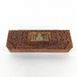 ÍNDIA - Caixa em madeira talhada decorada com imagem do Taj Mahal em metal dourado. Dimensões: 20 cm x 6 cm x 5 cm.