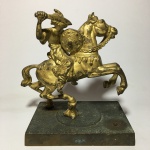 Antiga e bela escultura de "Tuareg em cena de ataque" em bronze. Base  retangular em metal cinzelado. Presença de desgastes no revestimento. Dimensões: 17 cm de altura / Base mede 9,5 cm x 14 cm.