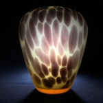 Belo vaso em vidro satinado na cor âmbar decorado com detalhes profusos em tons de marron. Presença de pequeno bicado na borda. Dimensões: 20 cm x 17 cm.