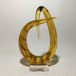 MURANO - Antiga e bela estatueta abstrata em pasta de vidro  na cor amarelo e base de cristal translúcido. Presença de ínfimo bicado na quina da base. Dimensões: 27 cm x 17 cm.