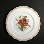 FRANÇA - Antigo e belo prato em fina porcelana esmaltada, decorado com arranjos florais ao centro. Borda ondulada e decorada com arabescos gravados a ouro. Dimensões: 21 cm