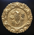 Belo medalhão em metal dourado , decorado com volutas perolados e ao centro cachos de  uvas . Dimensões: 25 cm / 1kg.