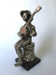 Estatueta metal cinzelado Homem com bandolim. Instrumento removível. Dimensões: 37 cm / 5 kg.