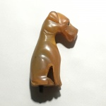 Antigo castão no formato de cão esculpido em galalite. Falta um olho. Dimensões: 7 cm.
