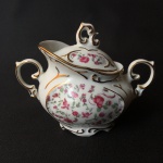 Belo açucareiro porcelana nacional, decorado com arranjos florais e realces pintados à Ouro. Dimensões: 13 cm x 10 cm x 17 cm.