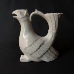 Bela jarra em porcelana no formato de ave. Dimensões:23 cm x 12 cm x 21 cm.