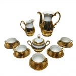 Serviço para café em porcelana esmaltada e vitrificado com realces dourados, constando de: Bule, leiteira, manteigueira e 5 xícaras pequenas. Falta tampa do bule, Pequenos desgaste do tempo. Dimensões: Bule 18 cm / xícaras com pires 5 cm x 10,5 cm.