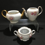 Conjunto com dois bules e um açucareiro em porcelana nacional.Pequenos sinais de desgastes.Falta as respectivas tampas.Maior peça: 14 cm altura.