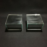 Delicado par de bases espelhadas. Dimensões: 5 cm x 10 cm x 10 cm.