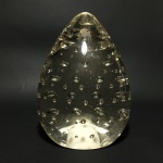 Escultura em pasta de vidro, formato ovóide, decorada com micro bolhas no interior. Dimensões: 12 cm.