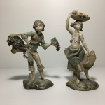 Duas estatuetas "Jovens comerciantes de frutas" em resina. Dimensões: 18 cm (maior peça).
