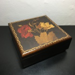 Antiga caixa em madeira marchetada decorado com arranjos florais e estilizados. Presença de fissura na parte de trás. Dimensões 7 cm x 17 cm x 17 cm.