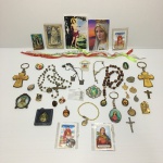 Lote contendo pingentes, broches, terços, escapulário de prata, orações, chaveiros e lembrança do senhor do Bonfim.