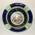 Antiga saladeira em porcelana esmaltada nas cores azul e verde, com centro galante ao centro. Detalhes pintados e gravados à ouro. Dimensões: 23 cm x 7 cm.