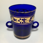 Balde para gelo em vidro na cor azul royal, com duas alças, decorado com faixa e filetes gravados à ouro. Dimensões: 14 cm x 12 cm.