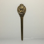 Abridor de carta em bronze de origem francesa com imagem do Napoleão Bonaparte e torre Eiffel em alto relevo. Dimensões: 18,5 cm.