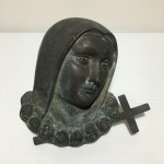 Busto de santa com uma cruz em bronze com pátina natural. Dimensões: 16 cm x 16 cm x 5 cm / 1,2 kg.