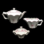 COIMBRA PORTUGAL  - Raro conjunto com bule, leiteira e açucareiro de porcelana esmaltada, facetado, decorado com arranjos florais na cor rosa. Dimensões: 15 cm x 17 cm x 27 cm (maior peça).