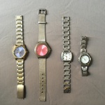 Lote com 4 relógios sendo um sem vidro e um com os ponteiros soltos. Todos os exemplares sem funcionamento.