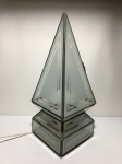Luminária de mesa no formato de pirâmide com armação de metal e placas de vidro. Dimensões: 42 cm altura.