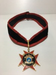 Medalha de metal dourado nas cores vermelho, preto e azul. Medalha está solta.