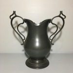 AMEARTE X MG - Antiga Ânfora de metal cinzelado com alças curvadas. Bojo  com pequena mossa. Dimensões: 26 cm altura / 1,5 kg.