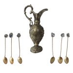 Lote com uma jarra de metal dourado, medindo 25 cm e seis colheres de chá decoradas com pedras polidas, medindo 10 cm.