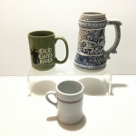 Lote com três canecas de porcelana esmaltada.Dimensões: 22 cm (maior peça).