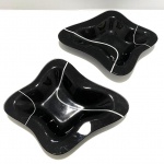 Dois pratos para servir de vidro nao cor preto com linhas brancas. Presença de pequenos arranhões. Dimensões: 3 cm x 21 cm x 25 cm.