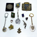 Lote com 13 itens: chaveiros, bottons e miniatura de revolver.