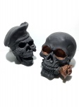 Duas cabeças de caveiras de resina na cor preto. Dimensões: 16 cm altura (maior peça).