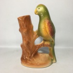 Delicada floreira em cerâmica esmaltada decorada com ave da fauna Brasileira, repousada sobre tronco. Dimensões: 25cm x 15cm x 5cm.