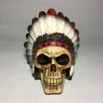 Estatueta de Caveira decorada com cocar. Belos detalhes. Dimensões: 14 cm x 14 cm x 11 cm.