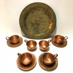 Prato indiano de metal decorado com arabescos incrustados e seis xícaras com quatro pires de cobre. Sinais de desgastes. Dimensões: 25 cm diâmetro (prato).