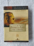 Livro "A Pedra da luz" Nefer, o Silencioso (Vol. 1). Livro usado em bom estado de conservação e leitura. / capa e contracapa com pequenos sinais de uso e manuseio, no estado veja foto, bom aspecto. / corte levemente amarelado pequenas manchas. O LIVRO Após o estrondoso sucesso da Série Ramsés em cinco volumes, que atingiu a marca de mais de 250 mil exemplares vendidos no Brasil, o egiptólogo Christian Jacq lança A Pedra da Luz, uma série composta por quatro volumes: Vol. 1 - Nefer, O Silencioso, Vol. 2 - A Mulher Sábia, Vol. 3 - Paneb, O Ardoroso; e Vol. 4 - O Lugar da Verdade. Christian Jacq nos inicia em uma aventura cativante, passada nos últimos dias do reinado do Faraó Ramsés. Em uma cidade proibida, encravada no deserto montanhoso do Alto Egito, é guardado o mais precioso segredo dos Faraós: A Pedra da Luz, capaz de transformar pó em ouro e a matéria em luz. Obcecado pelo segredo, o ambicioso Mehy ronda a cidade proibida e se encanta com a pedra, desejando obtê-la a todo custo, com o propósito de dominar o Egito. Nefer, O Silencioso, um dos homens mais devotados ao Faraó, tentará deter o maléfico Mehy, que trama assassinar o soberano. O AUTOR Christian Jacq nasceu em Paris, em 1947. Egiptólogo renomado, é doutor em Estudos Egípcios pela Sorbonne. Em 1995, lançou a Série Ramsés, em cinco volumes, que o consagrou definitivamente na carreira literária. A série já vendeu mais de 11 milhões de livros em 29 países em todo o mundo.