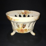 Antiga fruteira em cerãmica com 3 pés com decorações florais. Marcas do tempo e bicado na borda.Dimensões: 14 cm x 20 cm .