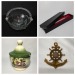 Lote contendo: Bela e delicada cesta em vidro com alça em acrílico decorada com morangos e folhagens em alto relevo. Dimensões: 20 cm x 16 cm. / Bela lapiseira com estojo. / Antigo pote em cerâmica esmaltada, decorado com arranjos florais pintados à mão. Presença de pequeno bicado da tampa. Dimensões: 15 cm altura. / Porta - chaves em resina no formato de âncora. Dimensões: 23 cm x 20 cm.