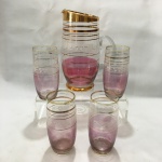Bela e antiga jarra com 4 copos em vidro , decorados nos tons de rosa e filetados a ouro. Presença de marcas do tempo.Dimensões: Jarra 23 cm x 15 cm . / copo 14 cm.