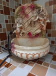 Fonte de água, decorativa, de resina, funcionando, decorada com querubins. Dimensões: 25 cm altura aproximadamente.