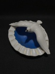 GEROLDO PORZELLAN - BAVARIA - ALEMANHA ANOS 40 - Antigo cinzeiro de porcelana esmaltada com figura de ave nas cores azul e branco com realces dourados. Pequeno bicado na asa e no bico da ave. Dimensões: 7 cm x 13 cm x 17 cm.