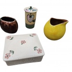 Quatro peças em cerâmica, sendo dois vasos um na cor marrom e um amarelo apresenta descascado na borda e dois potiches um circular decorado com fruta. Maior                                                                                                   