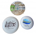 Terno de pratos decorativos em porcelana representando lembranças das cidades de Petrópolis, Florianópolis e Tiradentes. Med. Diam. 20 a 15cm 