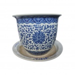 Cachepot e presentoir em porcelana chinesa decorado com flores e arabescos em azul indico sobre fundo branco, apresenta lascado na borda. Med. alt. 22cm x diam. 27cm e presentoir diam.32cm